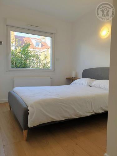 une chambre avec un grand lit avec une fenêtre dans l'établissement Maison à Malo les bains à 5mn de la plage, à Dunkerque