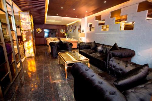a living room with leather couches and a table at The Elite Residence Dhaka in Dhaka