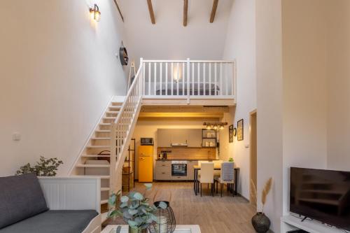 a living room with a staircase and a kitchen at STODOLA NA VSI in Poděbrady