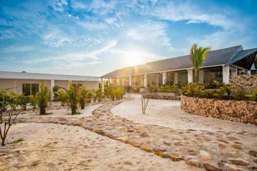 a building on the beach with the sun shining at You&Me Resort in Koh Rong Island