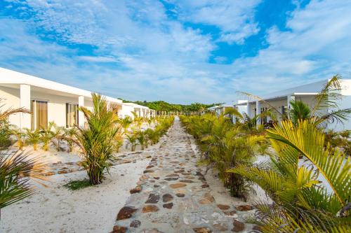 a pathway through the beach with houses and palm trees at You&Me Resort in Koh Rong Island
