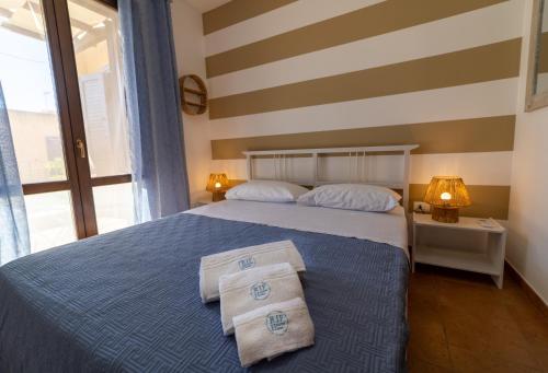 1 dormitorio con 1 cama con 2 toallas en Rif Holiday Home Stagnone Marsala en Birgi Vecchi