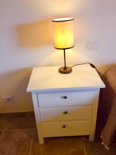 a lamp sitting on a dresser next to a bed at Laura Chianti Vacanze in Poggibonsi