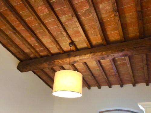 a light hanging from a ceiling with a wooden ceiling at Laura Chianti Vacanze in Poggibonsi