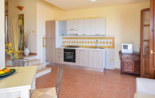 una cucina con mobili bianchi e un forno a piano cottura di Casa Gallinelle sarde a Castelsardo