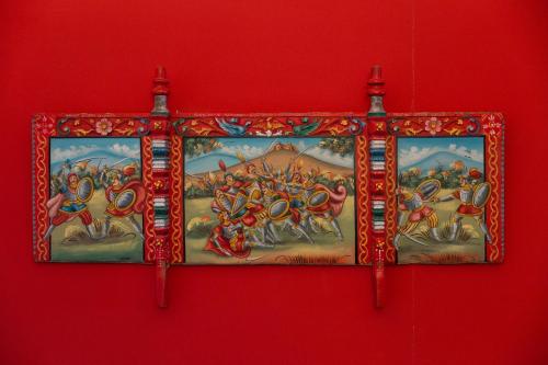a painting hanging on a red wall at B&B Bellini in Milo