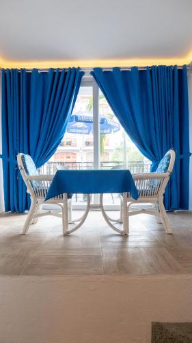 a blue table and two chairs in front of a window at Clarkton Hotel Apartment in Angeles
