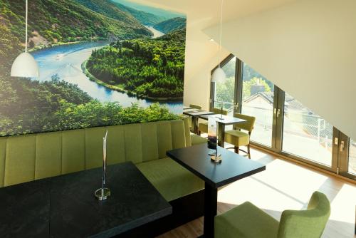 a dining room with a view of a river at Vis Saar Vie - Ferienwohnungen an der Saarschleife in Mettlach