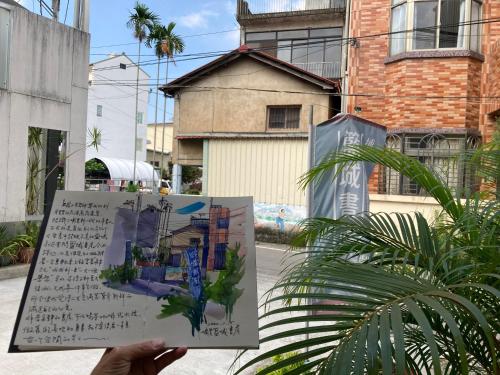 a person holding up a sign in front of a building at Read to Sleep Book & Bed in Puli