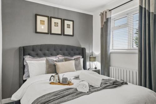 una camera da letto con un letto e un vassoio di cibo sopra di Stunning 2-bedroom house with free parking & WiFi a Chatham