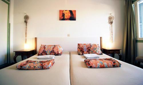 two beds with pillows on them in a room at Lima Sol House in Limassol