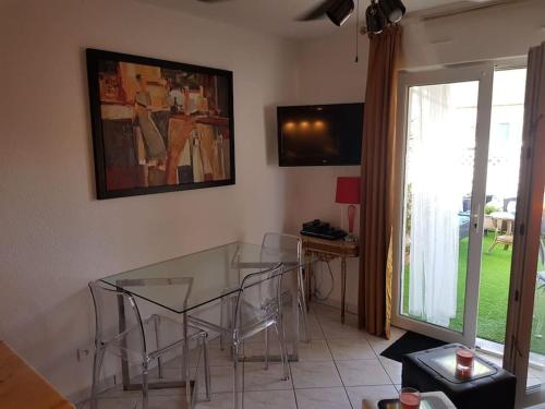 a dining room with a glass table and chairs at Clair de plage in Frontignan
