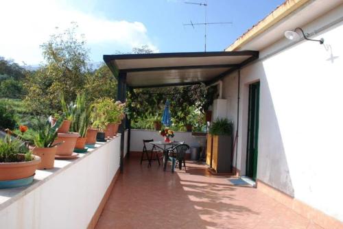 a patio with potted plants and a table at Casa Galatea Etna nord via Bellini 141 Milo in Milo