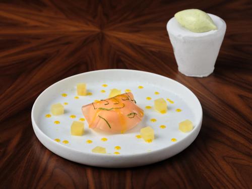a white plate with a piece of food on a table at Hôtel Richer De Belleval - Relais & Châteaux in Montpellier