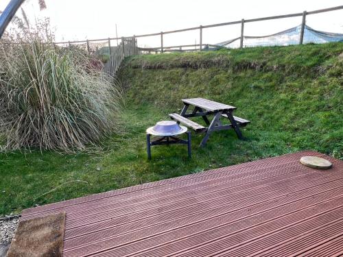 a picnic table and bench with a frisbee on it at Stonehenge Campsite & Glamping in Berwick Saint James