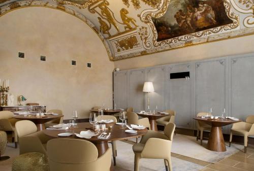 a restaurant with tables and chairs and a ceiling at Hôtel Richer De Belleval - Relais & Châteaux in Montpellier