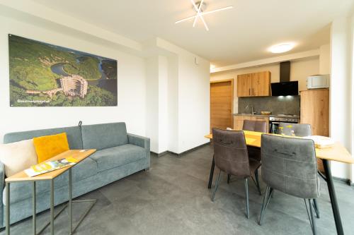 a living room with a couch and a table at Vis Saar Vie - Ferienwohnungen an der Saarschleife in Mettlach
