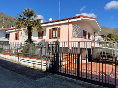 Pozzilli的住宿－Villa Antonella，粉红色的房子,前面有栅栏