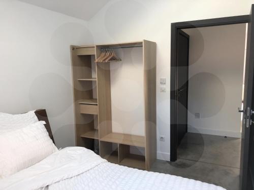 ein Schlafzimmer mit einem Bett und einem offenen Schrank in der Unterkunft L'atelier 1410 in Saint-Amand-les-Eaux