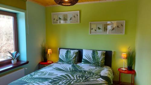 a green bedroom with a bed and a window at B&B Emarik in Podobin
