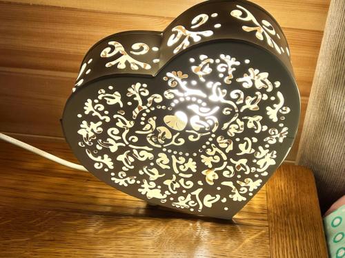 a black and white heart on a wooden table at Stonehenge Campsite & Glamping in Berwick Saint James