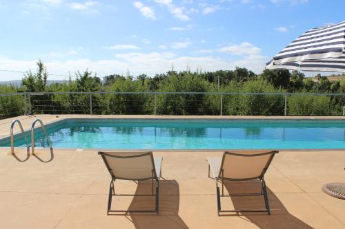 duas cadeiras em frente a uma piscina em Villa Martins em Lagoaça