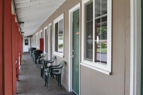 a hallway with chairs and windows on a building at Jumping Frog Motel in Angels Camp
