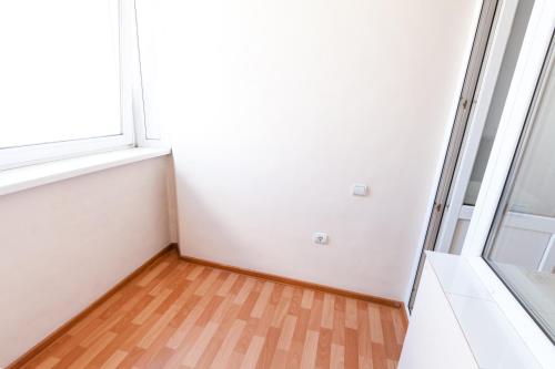an empty room with a window and a wooden floor at Центр! Красноармейский 69б-13 in Barnaul