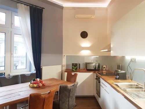 a kitchen with a table with a bowl of fruit on it at Luxurious Apartment with Balconies in DownTown BP in Budapest