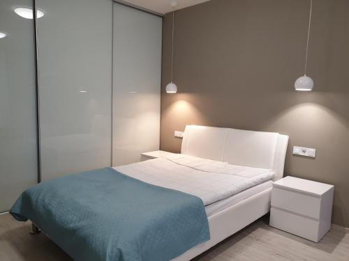 1 dormitorio con cama blanca y manta azul en Best Apartment Shevchenka 80, en Leópolis