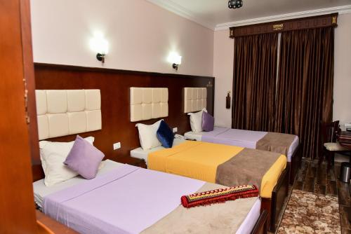 a hotel room with two beds and a table at Grand Hotel Ras Elbar in Ras El Bar