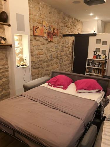 une chambre avec un grand lit avec des oreillers rouges dans l'établissement A very calm Loft in Bastille, à Paris