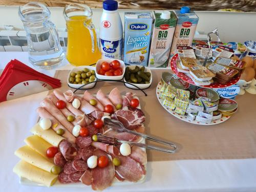 a table topped with cheese and meats and other foods at Guest house Slatki Snovi in Knin