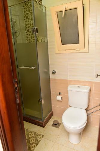 a bathroom with a toilet and a glass shower at Grand Hotel Ras Elbar in Ras El Bar