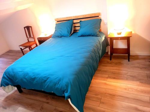 1 cama grande con sábanas azules en una habitación en Gîte La Glycine en Dun