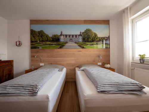 two beds in a room with a painting on the wall at Fewo Papst Nordborchen in Nordborchen