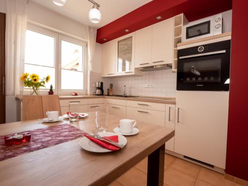 a kitchen with white cabinets and a wooden table at Fewo Papst Nordborchen in Nordborchen