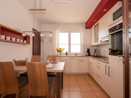 a kitchen with white cabinets and a wooden table at Fewo Papst Nordborchen in Nordborchen