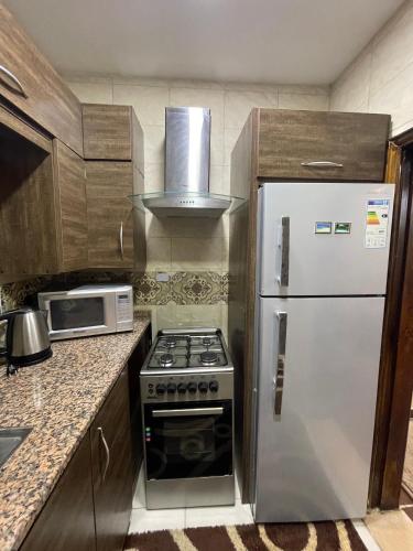 a kitchen with a white refrigerator and a microwave at Oqdeh studio in Jerash