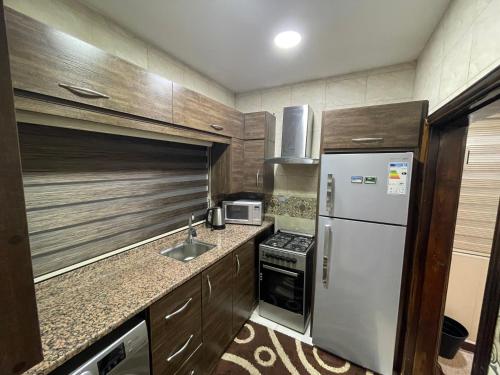 a small kitchen with a refrigerator and a sink at Oqdeh studio in Jerash