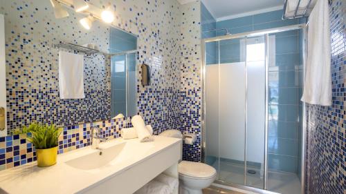 a bathroom with a toilet and a sink and a shower at Tabbu ibiza apartments in Playa d'en Bossa