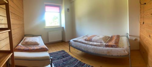 a small room with two beds and a window at Domek wiejski in Dwernik