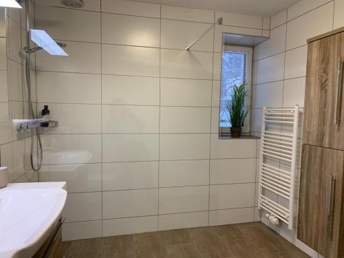 een badkamer met een wastafel, een bad en een raam bij Schusterbrand Appartements in Absam