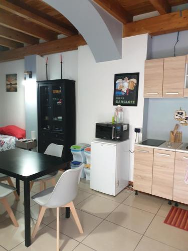a kitchen with a black refrigerator and a table and chairs at ROMEO2 in Somma Lombardo