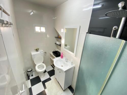 a bathroom with a toilet and a sink and a mirror at Desert Pearl Arad in Arad