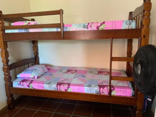 1 dormitorio con 2 literas con sábanas rosas en Casa de temporada no centro de arraial do cabo, en Arraial do Cabo