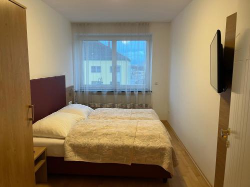 a small bedroom with a bed and a window at Tinschert Hotel-Restaurant-Partyservice in Schwertberg