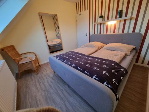 a bedroom with a large bed and a mirror at Haus Ebbe und Flut Dagebüll in Dagebüll