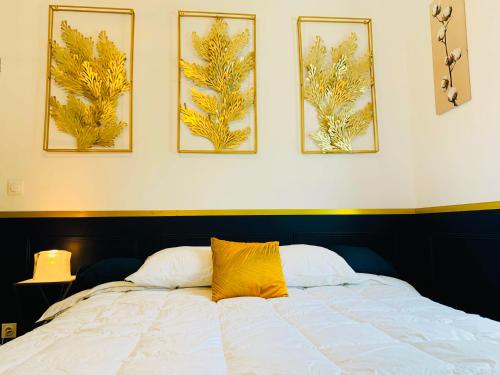 ein Schlafzimmer mit einem Bett mit vier Bildern an der Wand in der Unterkunft Homard & Fox, Le Féart, Studio avec coin terrasse & barbecue in Dinard