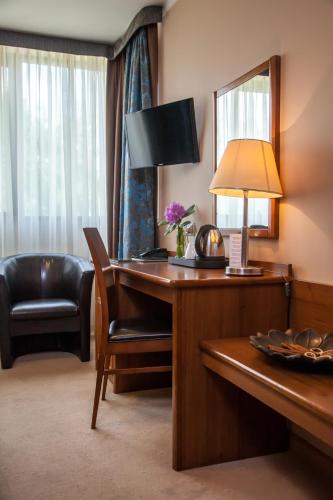 a hotel room with a desk and a chair at Farmona Hotel Business & SPA in Kraków